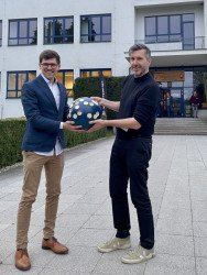 Předání autorské koule od architekta Pavla Horáka z Prodesi Domesi na konferenci ve Volyni.