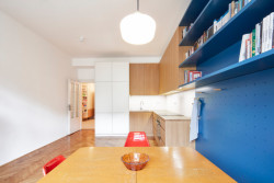 Vestavné vybavení dostalo v hlavním obytném pokoji modrou barvu a dřevodekor. (Rekonstrukce bytu na Letné; 0,5 Studio)