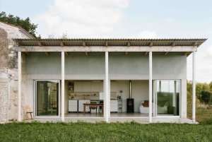Konverze starého statku, Martin Migeon Architecture: Nová přístavba rozvíjí svůj charakter skrze souběh tří prvků: dřevěná fasáda, odhalená betonová konstrukce a kolonáda z kulatých betonových sloupů.