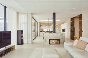 Impozantní krb jemně odděluje ryze odpočinkovou obývací část od jídelního prostoru. (Bungalov ve východních Čechách; Atelier Kunc)