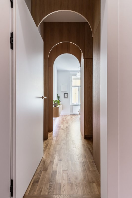 Elegantní řešení oblouků zjemňuje chodbu a pouští světlo hluboko do interiéru. (Byt v Karlíně; momentura)