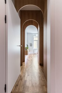 Elegantní řešení oblouků zjemňuje chodbu a pouští světlo hluboko do interiéru. (Byt v Karlíně; momentura)