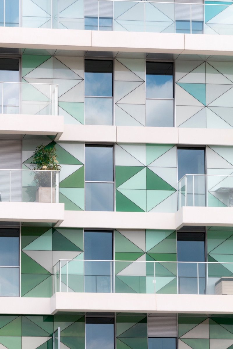 Bytový dům ve Francii s fasádou, kombinující kontaktní zateplovací systém StoTherm Classic, předsazený provětrávaný zateplovací systém StoVentec Glass, složený ze skleněných panelů různých tvarů a bílý fasádní povrch StoSignature.