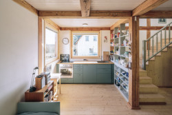 Chata Skelná Huť, re:architekti: Obytný prostor, kuchyň a otevřené schodiště nejsou nijak odděleny. Vzniká tak plynulý a vzájemně se prolínající prostor.