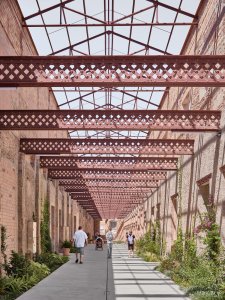 Otevřená průchozí pasáž slouží jako komunikační tepna. (Sociální projekt v bývalé textilní továrně; H ARQUITECTES)