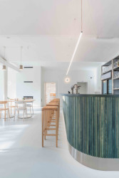 Zelený bar je v kontrastu s okolními neutrálními materiály a barevně tlumeným prostředím. (Interiér restaurace Blatenský dvůr, Dominik Cvrček)