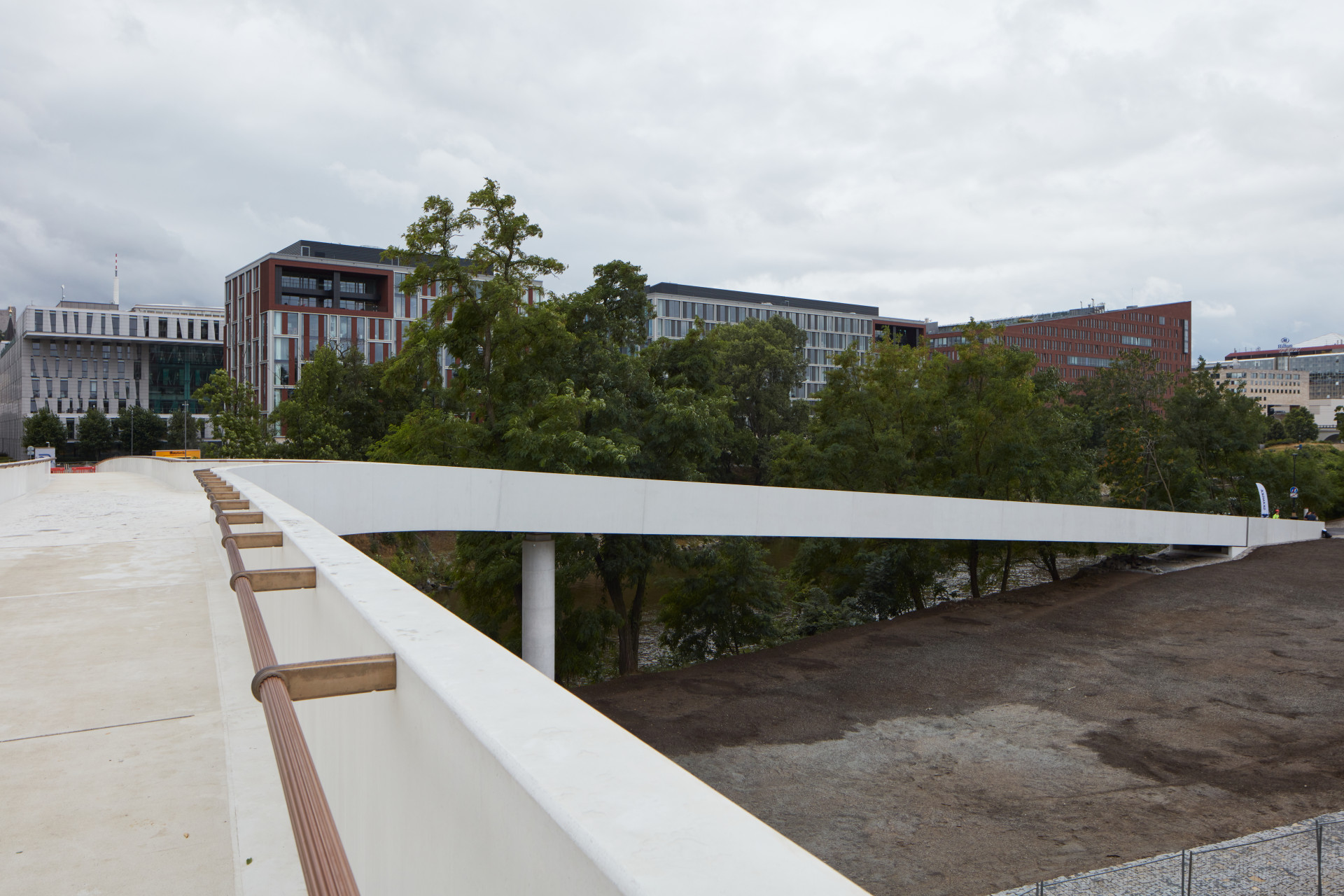 Bronzové zábradlí v sobě chytře ukrývá LED pásky. Ty jsou umístěny ve spodní hraně zábradlí a nejsou tudíž vidět. Toto elegantní řešení umožnilo eliminaci lamp a jiných svítidel, které by jinak mohly čistou a jednoduchou formu lávky narušit.