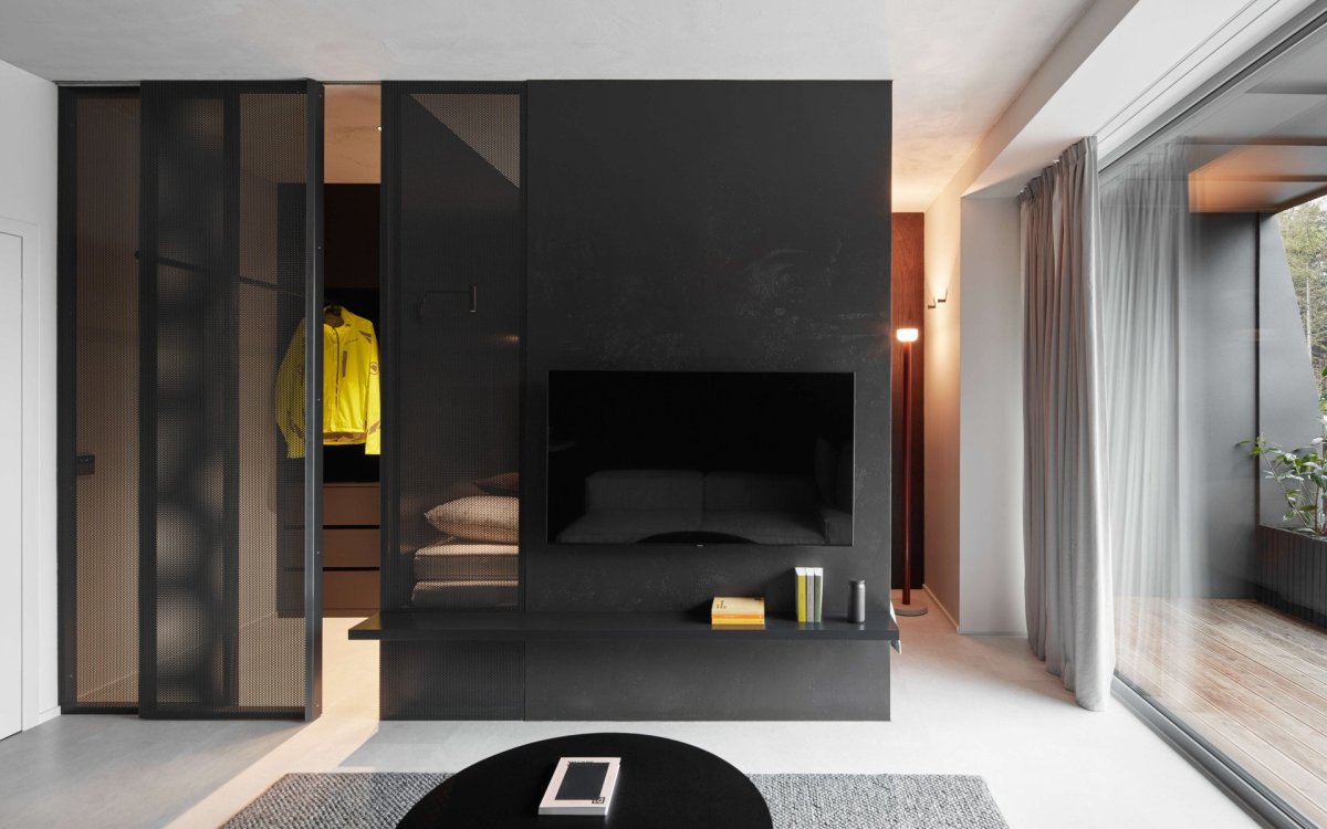 Stěna oddělující obývací část od ložnice je součástí celé kompozice nábytku, který tvoří postel, větratelnou šatnu a úložné prostory (Apartmán v Jizerských horách, MAVA ARCHI)