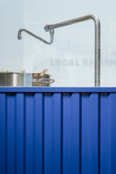 Detail pultu propojeného s otevřenou kuchyní (Bistro Ramencraft v Praze, SAO Architekti)