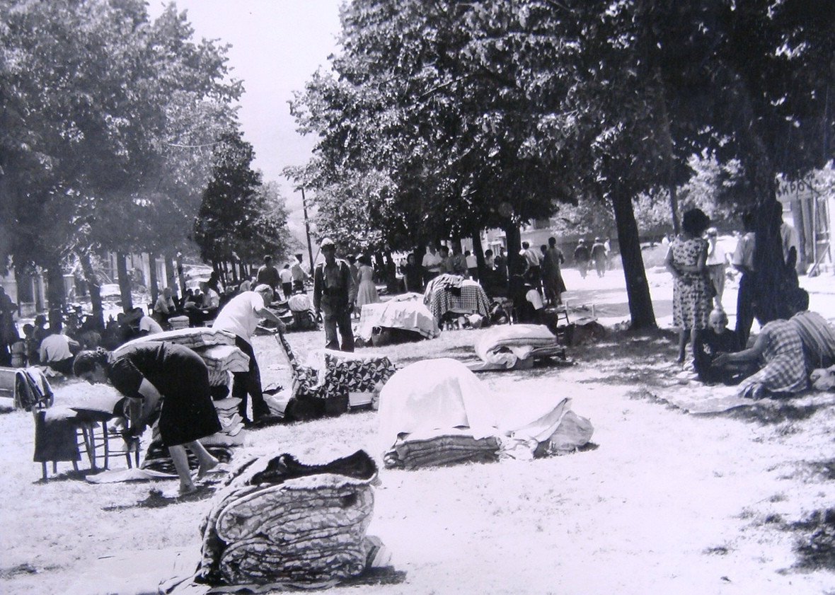 Den po zemětřesení, lidé si připravují provizorní lůžka v ulicích a parcích města.