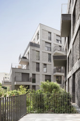 Studio AVENIER CORNEJO architectes navrhlo na břehu kanálu na předměstí Paříže obytný soubor třech domů s různým odstínem lícových cihel