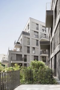 Studio AVENIER CORNEJO architectes navrhlo na břehu kanálu na předměstí Paříže obytný soubor třech domů s různým odstínem lícových cihel