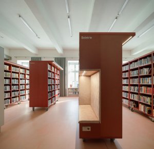 Červeno-růžové regály jsou pak rozmístěné v prostoru. (Knihovna v Červeném Kostelci; Papundekl architekti)