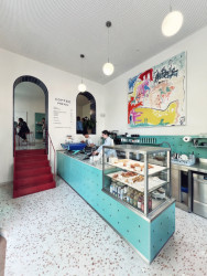 Červené kovové schodiště vyrovnává výškový rozdíl mezi dvěma prostory. (Onesip Coffee, edit!)