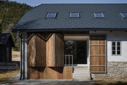 Nová okna otevírají interiér směrem ke krajině, velké okenice jej naopak chrání před větrem, sněhem i pohledy kolemjdoucích. (Rekonstrukce chalupy Borová Lada; Studio Plyš)