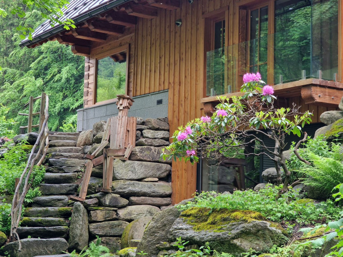 Rozsáhlá prosklená plocha a velká okna v roubence opticky rozšiřují interiér a navozují pocit volnosti.