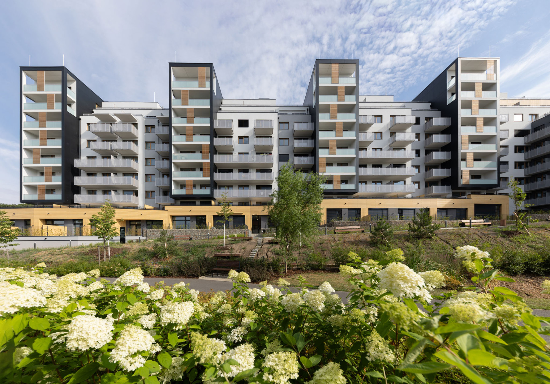 Čtyři věže s lodžiemi obložené černými deskami.