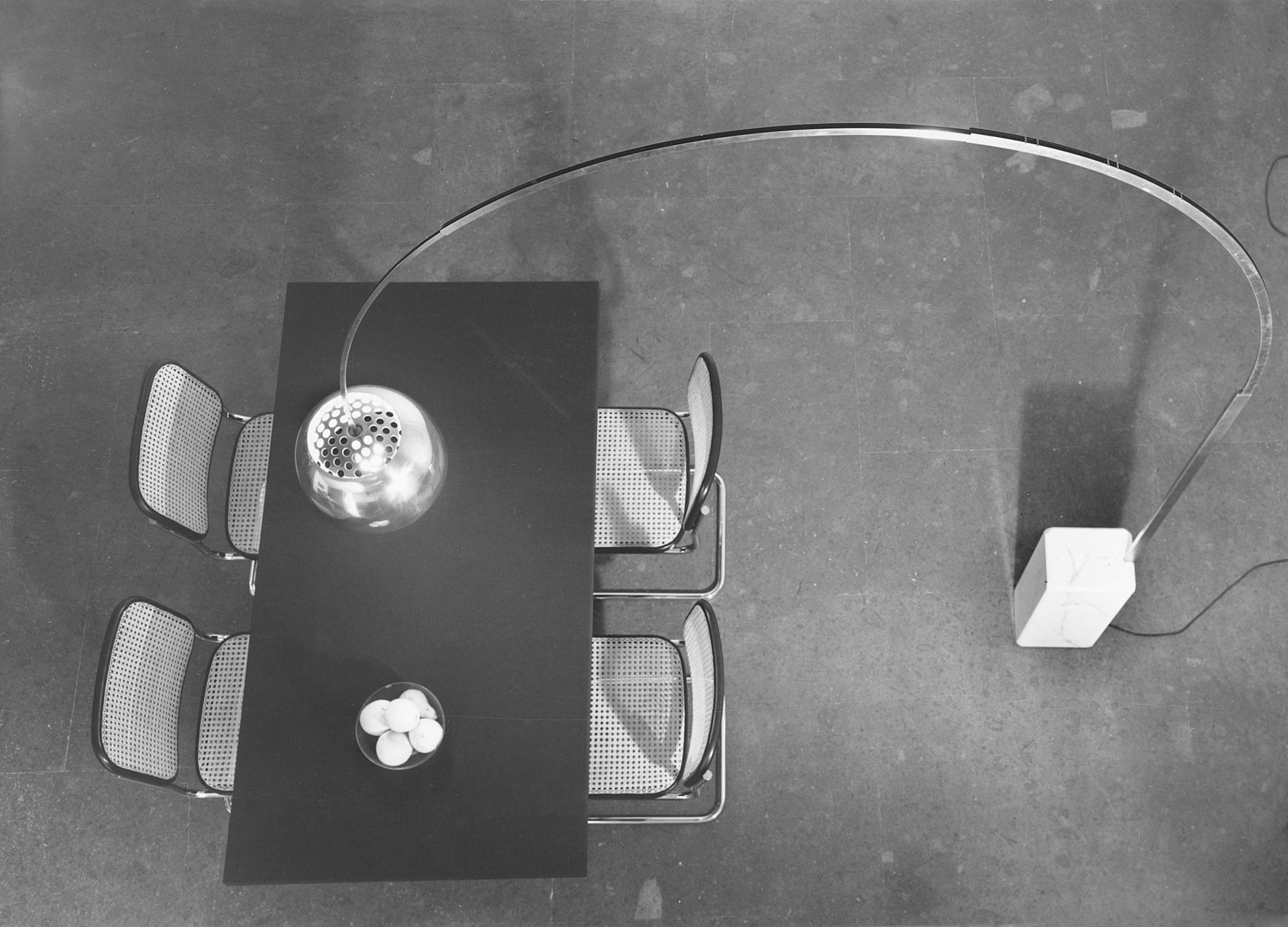 Arco je charakteristická svým dlouhým obloukem z nerezové oceli upevněným na mramorové, více jak šedesátikilové základně. (Design bratrů Achilla a Piera Giacomo Castiglioni)