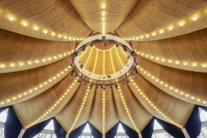 Působivá architektura stavby „Knies Zauberhut“ je v interiéru obložena vrtanými ohýbanými deskami NOVATOP, které plní zároveň akustickou funkci.  Architekt: Carlos Martinez Architekten AG
