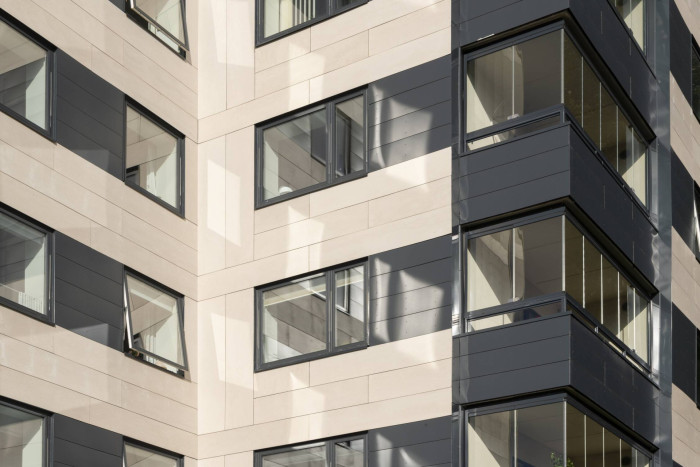 Bytový dům Jelling ve Vejle v Dánsku obložen černými deskami Swisspearl Zenor a fasádními panely Swisspearl Patina Original v pískové barvě.