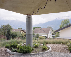 Rodinné komunitní bydlení ve Villy, Madeleine architectes, Studio François Nantermod: Krytý vstup do objektů v rozích podpírají výrazné kulaté betonové sloupy