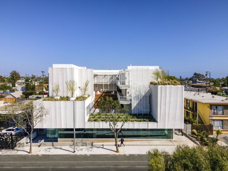 Rose Apartments se nachází přímo naproti základním obchodům, takže každodenní život lze zvládat i bez auta. (Rose Apartments v Los Angeles, Brooks & Scarpa)