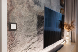 Dominantou prostoru obývacího pokoje je luxusní kamenná dýha na stěně s televizí.