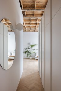 Byt G, Grau Architects: Místo, aby oddělili vstupní prostor od zbytku bytu příčkou, vytvořili architekti zádveří za pomoci delší šatní skříně mezi vstupem a ložnicí