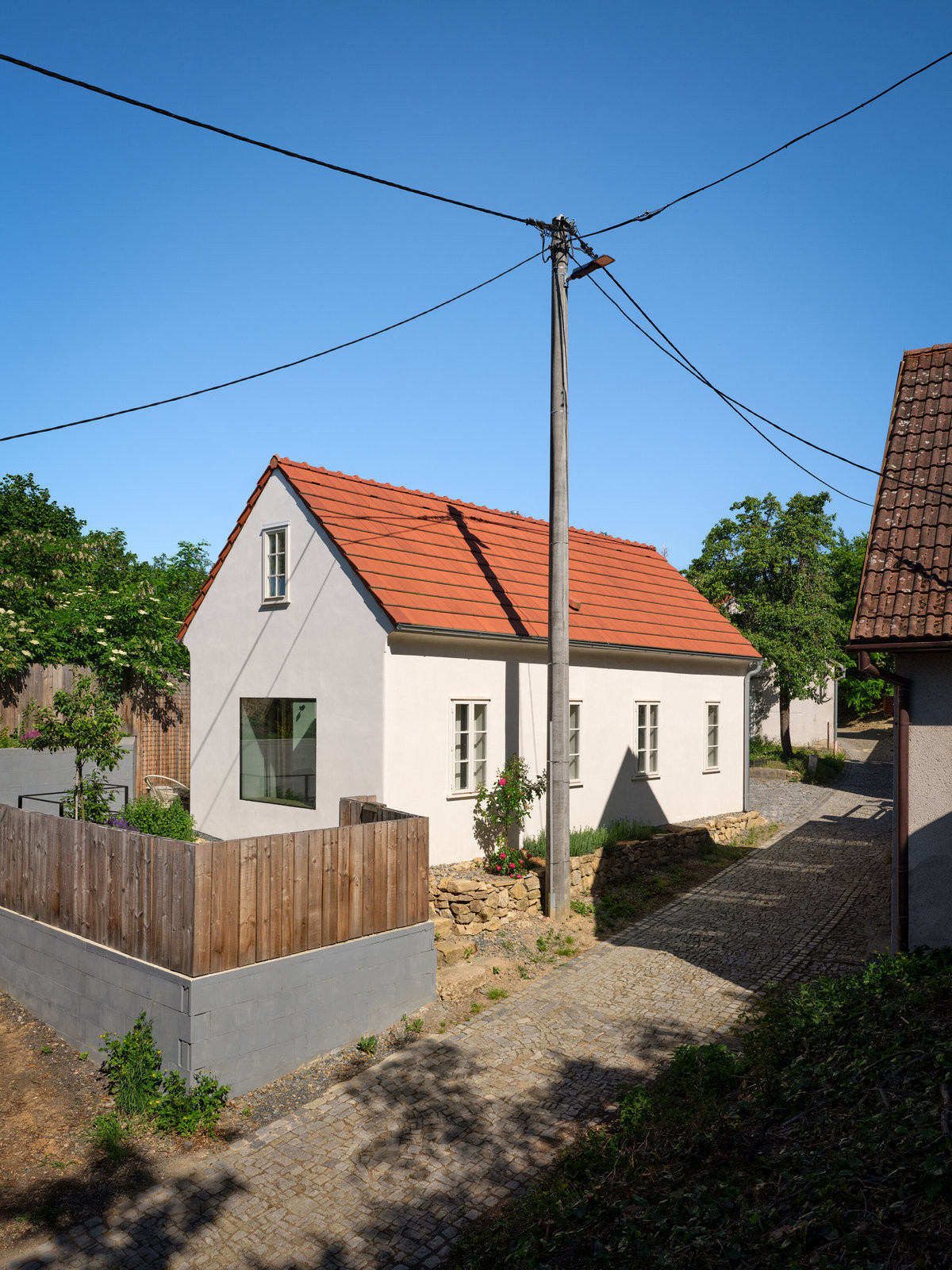 Víkendový domek stojí v sevřeném prostředí drobných staveb, sklepů a dvorků. (Bukovanský domeček; SENAA architekti)
