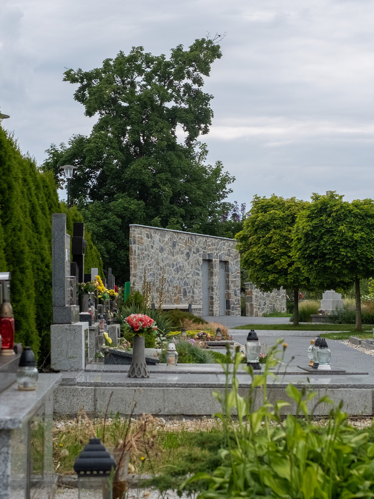 Místo pro odpadové nádoby elegantně maskuje zídka ze stejného materiálu, která navazuje
na zázemí. (Zázemí hřbitova; bydloarchitekti)