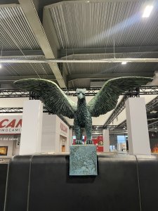 Motiv gryfa vychází z historických symbolů evropské kamnářské tradice.