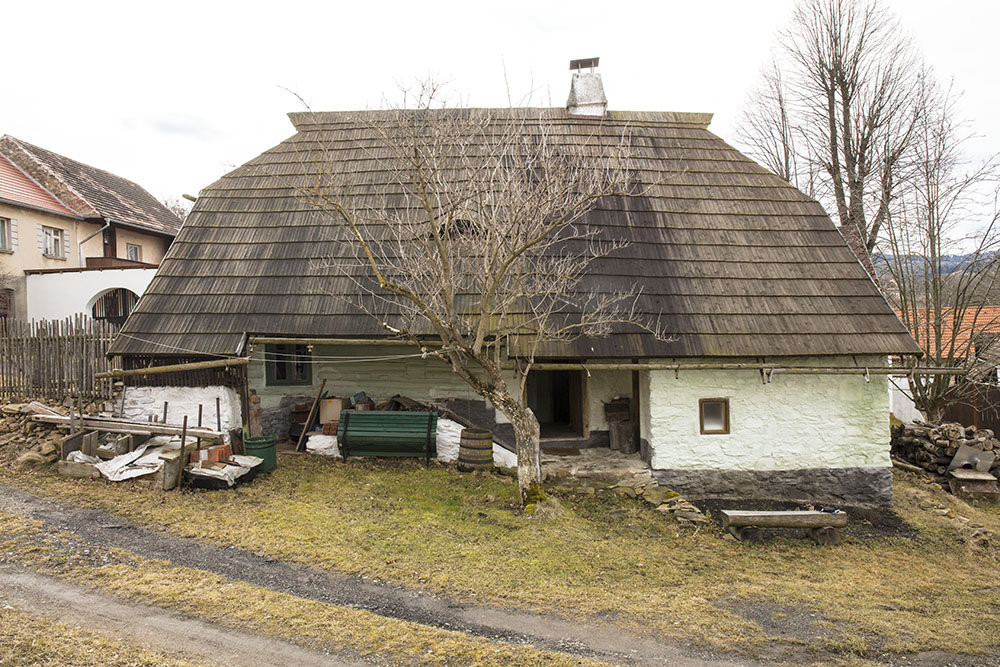 Před rekonstrukcí byla natřená "chalupářskou hnědí", teď má vápenný nátěr s nádechem do zelena. (Roubená chalupa Strašín)