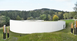 Za novým návštěvnickým centrem osady Ploština stojí studio Art Consultancy.