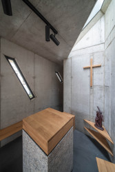 Oltář osvětluje střešní světlík. (Kaple v Praze-Záběhlicích; JIRSA – ARCHITEKTI)