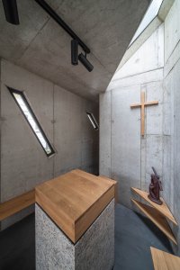 Oltář osvětluje střešní světlík. (Kaple v Praze-Záběhlicích; JIRSA – ARCHITEKTI)