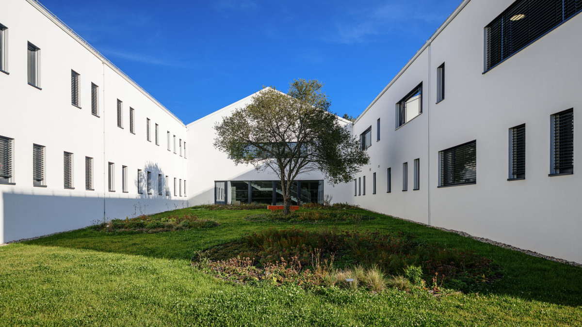 Pohled do jednoho z polootevřených atrií se zelení. (Dětská léčebna se speleoterapií v Ostrově u Macochy; Adam Rujbr Architects)