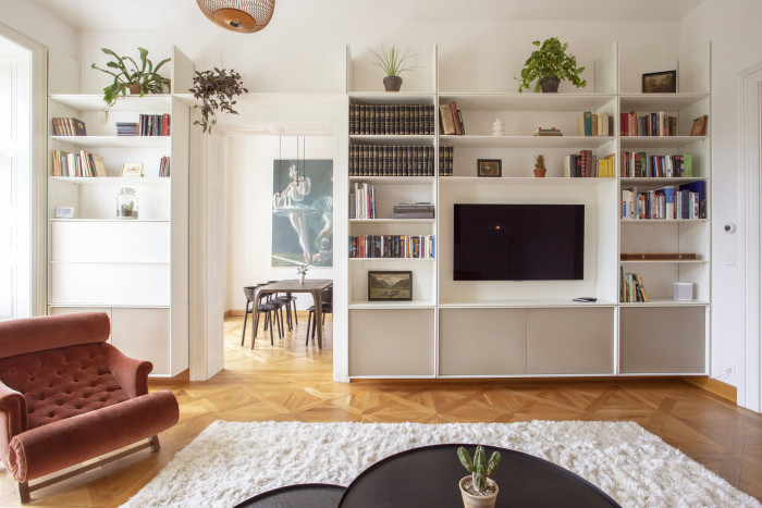 Dominantou obývacího pokoje je knihovna přes celou stěnu. (Byt na nábřeží, DDAANN)