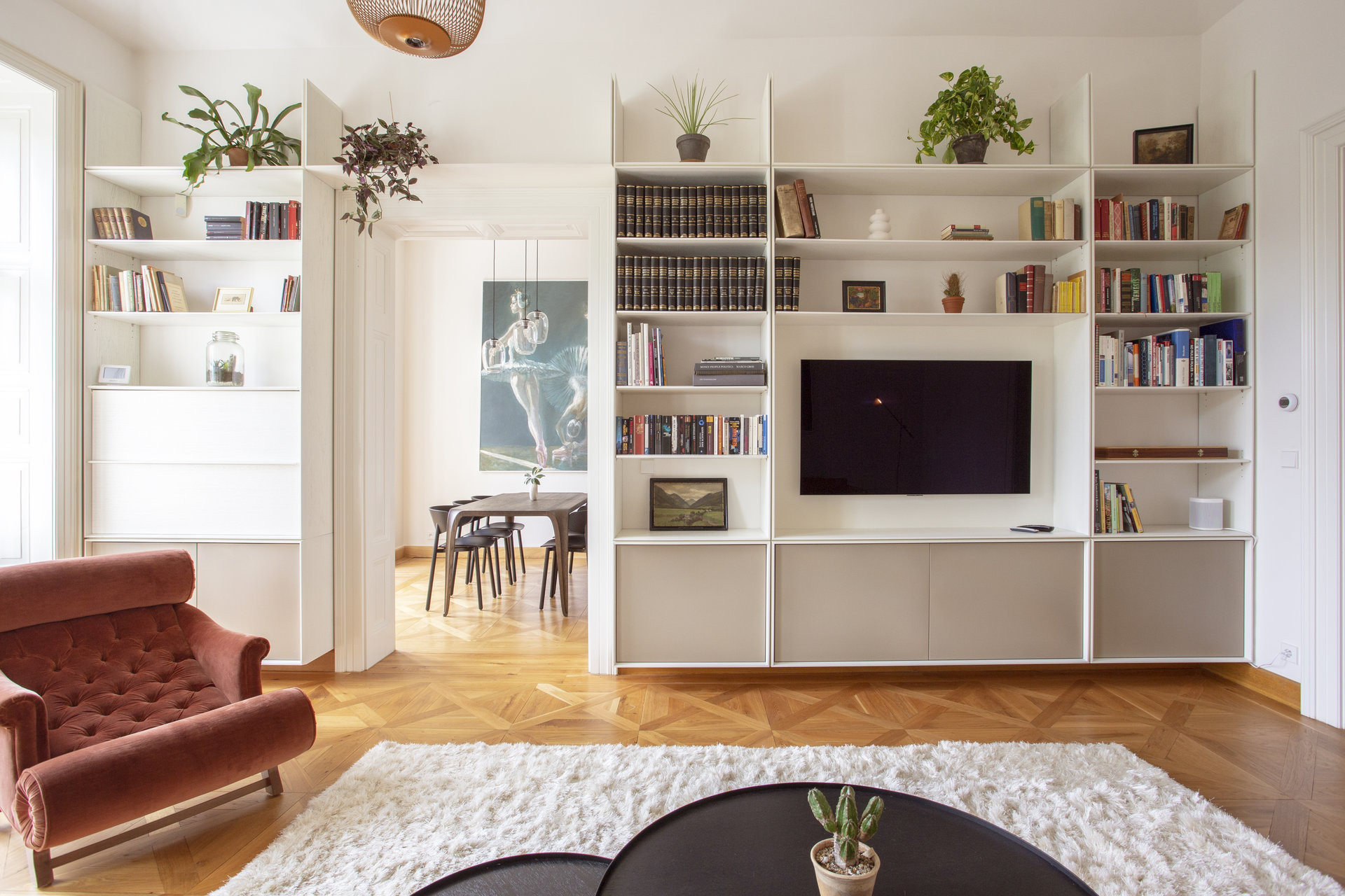 Dominantou obývacího pokoje je knihovna přes celou stěnu. (Byt na nábřeží, DDAANN)