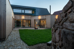 Rodinný dům v Bystřici nad Perštejnem, studio AEIOU: Trojkřídlá struktura svírá vnitřní dvůr, kterým se táhne dřevěná pobytová terasa