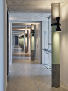Ve společných prostorech se dbalo na kvalitu prostorovou i designovou. (Konverze skladu vína na komunitní bydlení; Esch Sintzel Architekten)