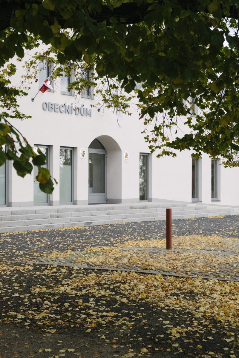 Hlavní vstup zvýrazňuje oblouk. Je tady taky nápis obecní dům a držáky na vlajky – to by měla mít ostatně každá budova s touto funkcí, je to otázka reprezentace. - Obecní dům v Dřísech, BY architects
