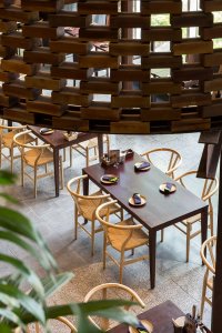 Válce jsou perforované a opticky vymezují soukromí prostor pro posezení u jídla. (Restaurace Pizza 4P’s v Hanoji od česko – vietnamského studia ODDO)