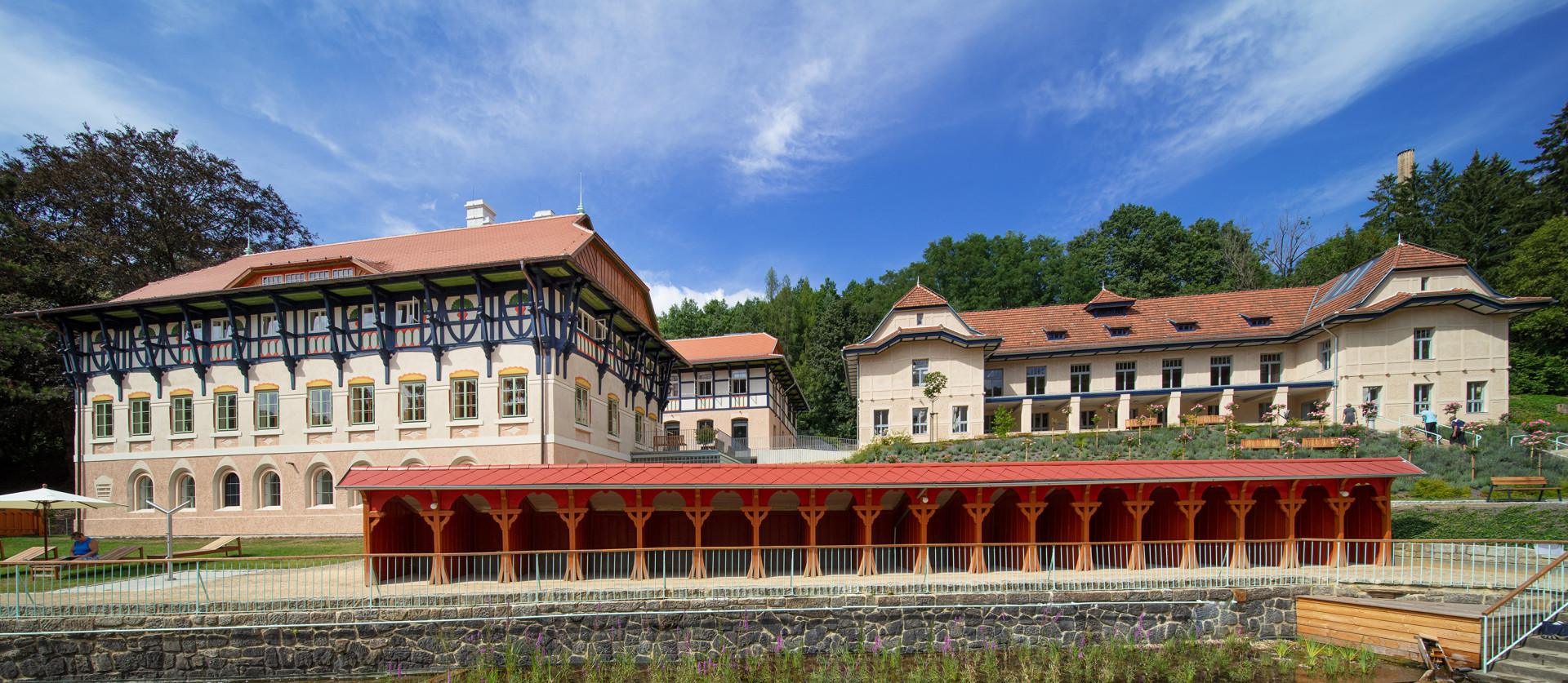 Vodoléčebný ústav (vlevo) a budova Sirných a slatinných lázní (vpravo) při pohledu od bazénu. (Sluneční lázně v Luhačovicích, TRANSAT architekti)