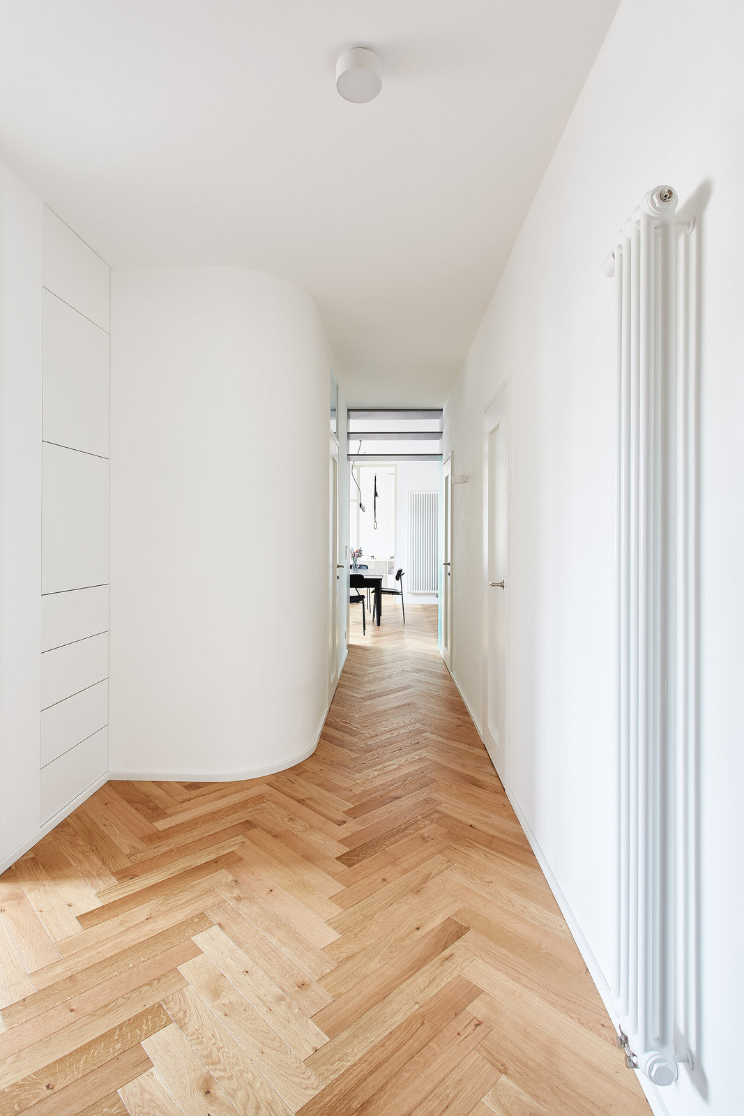Potřebnou měkkost a klid vnáší do prostoru zaoblené nároží koupelnového boxu v chodbě. (Flexibilní rekonstrukce pražského bytu; Markéta Bromová architekti)