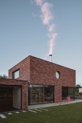 Obývací pokoj a dvě pracovny jsou propojeny se zahradou panoramatickými okny. (Cihlový dům v Pardubicích; architekti Jakub Dvořák a Michal Bílek)