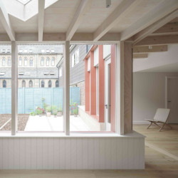 Přístavba rodinného domu v Londýně, Artefact: Paleta interiéru je doplněna bílým obkladem, žlutou knihovnou a stropem s přiznanými dřevěnými vazníky