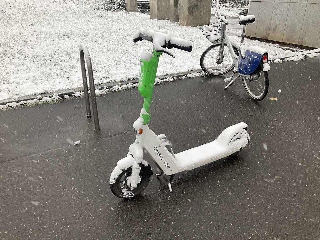 Sdílená elektrokoloběžka pod sněhem