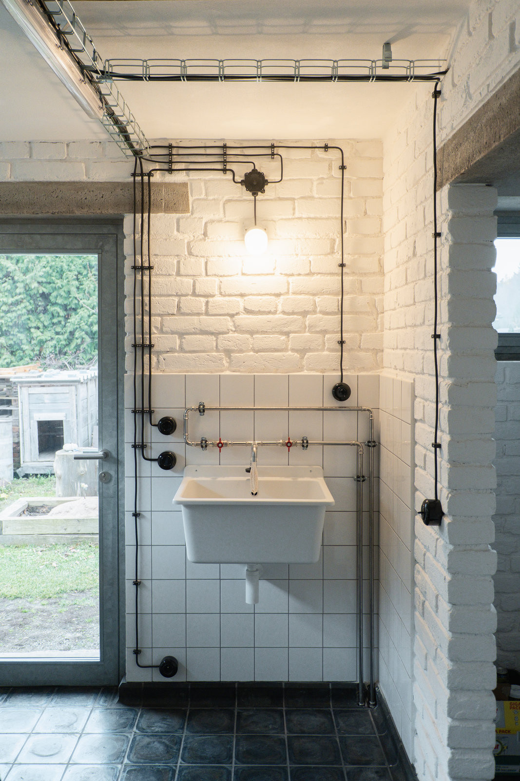 Dříve využívaný chlívek teď funguje jako technické zázemí sousedícího rodinného domu a zároveň malé wellness. (Terasa a zázemí ve stodole; tamti_architekti)