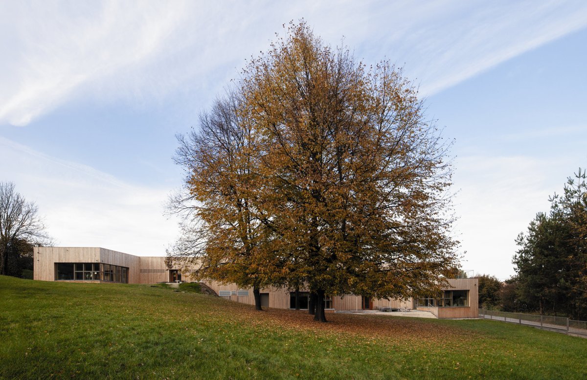 Ačkoliv je školka dvoupodlažní, architekti dokázali vhodně využít přirozeného terénního zlomu a rozčlenili stavbu tak, aby třídy zůstaly „při zemi“. (Mateřská škola ve Fulneku od XTOPIX)