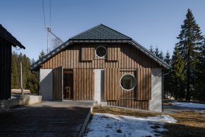 Nová okna otevírají interiér směrem ke krajině, velké okenice jej naopak chrání před větrem, sněhem i pohledy kolemjdoucích. (Rekonstrukce chalupy Borová Lada; Studio Plyš)